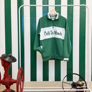 Cafe du Monde Zip Pullover in Green and White hanging up on a dresser