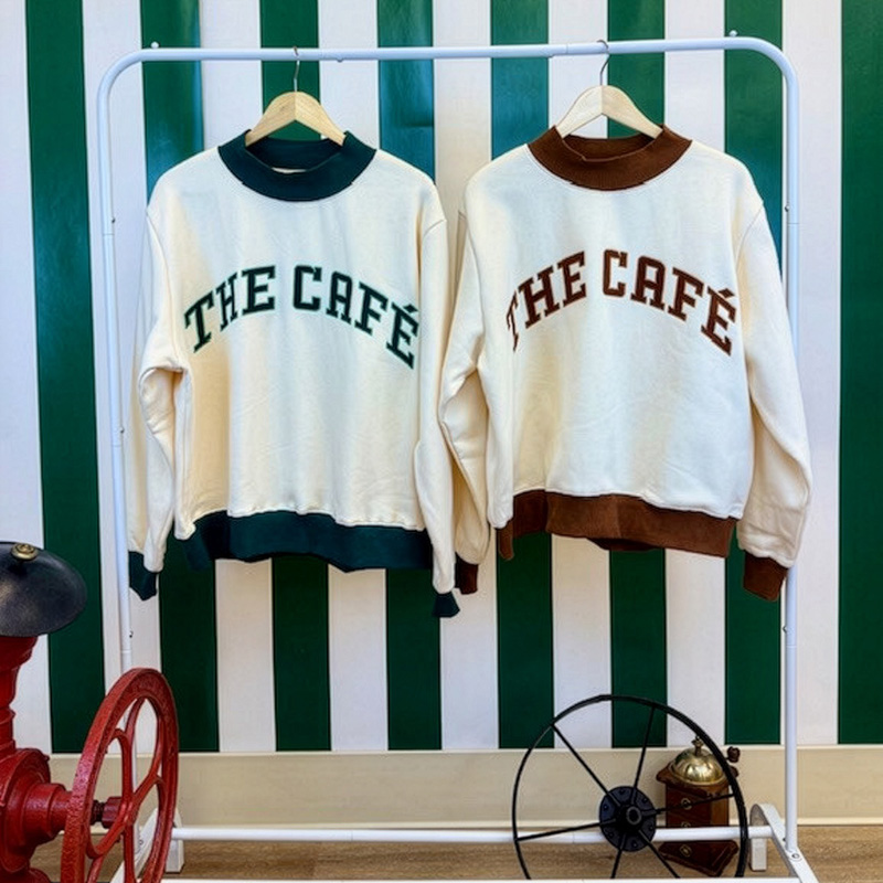 Café Sweaters in both green and brown trim hanging up